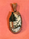 Copper wire wrapped Tree Agate pendant with hand-sculpted wire tree and sun on pink background