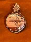Copper wire wrapped round Jasper pendant with hand-sculpted wire cactus and mountain scene on rust background