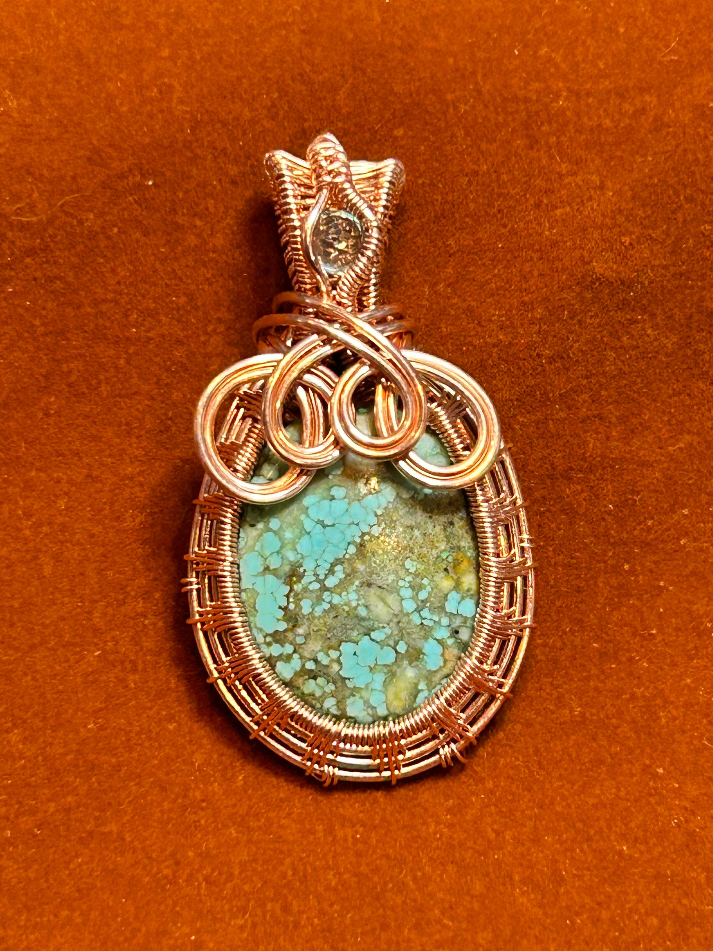 Copper basketweave wire wrapped Hubei Turquoise pendant with apatite accent on rust background