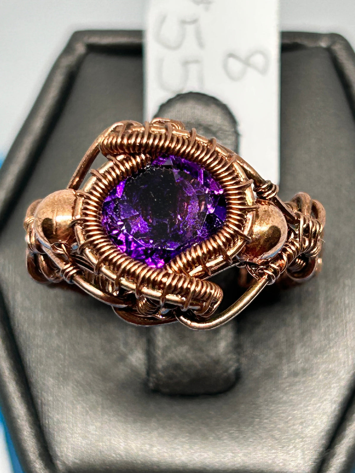 Copper wire wrapped faceted Amethyst ring size 8 with coiled bezel and copper bead accents on ring display