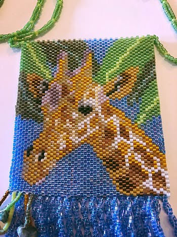 Close up of hand beaded giraffe portrait peyote stitch beadwork