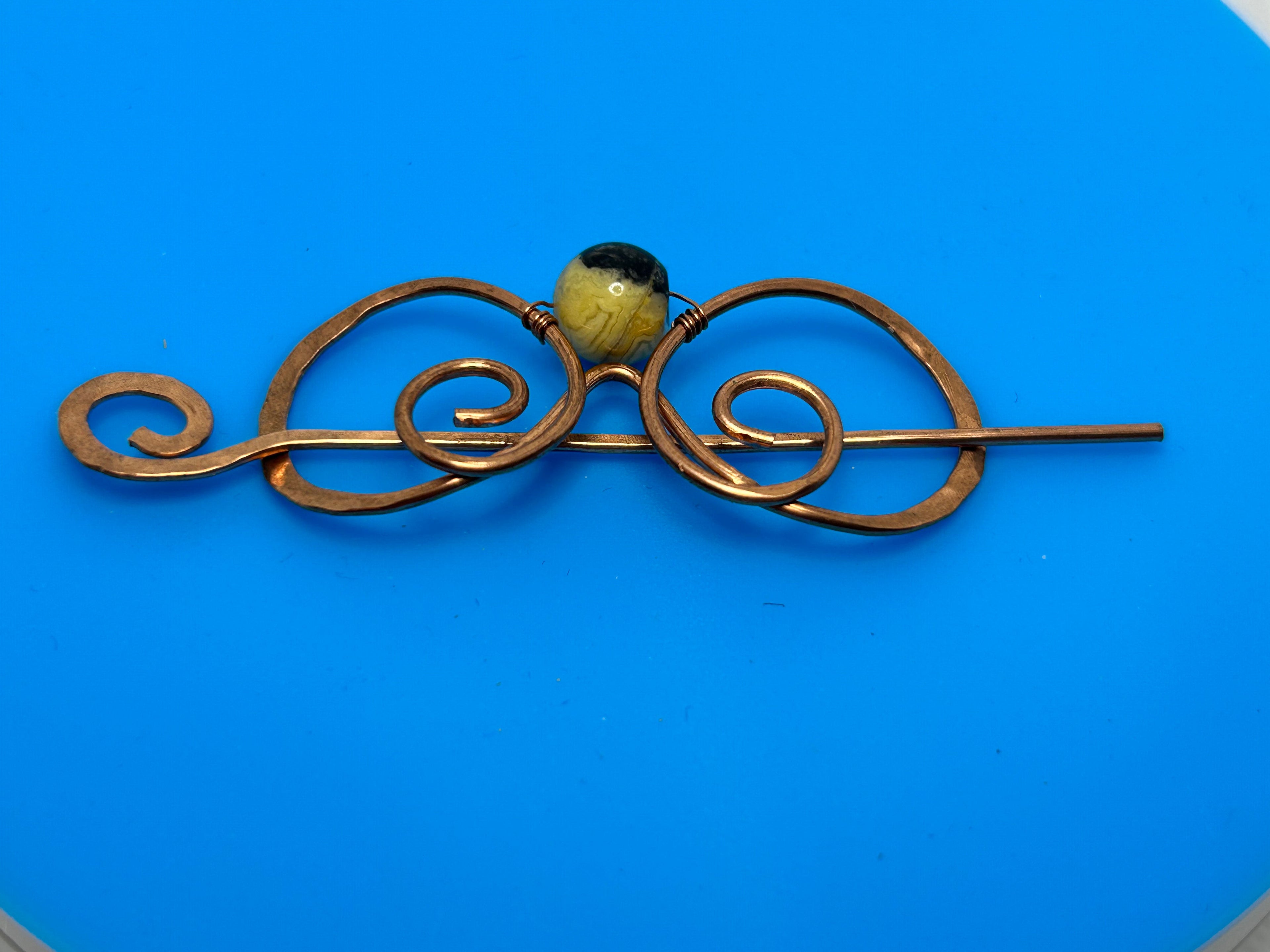 Hammered copper hair pin with lace agate bead center approximately 3 inches with scroll wave design