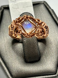 Copper wire wrapped rainbow moonstone diamond-shaped cabochon ring size 4 with scroll curl accents and wide woven band