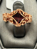 Copper wire wrapped garnet round cabochon ring size 4.5 with diamond frame cross setting and scroll curl cluster accents on wide woven band