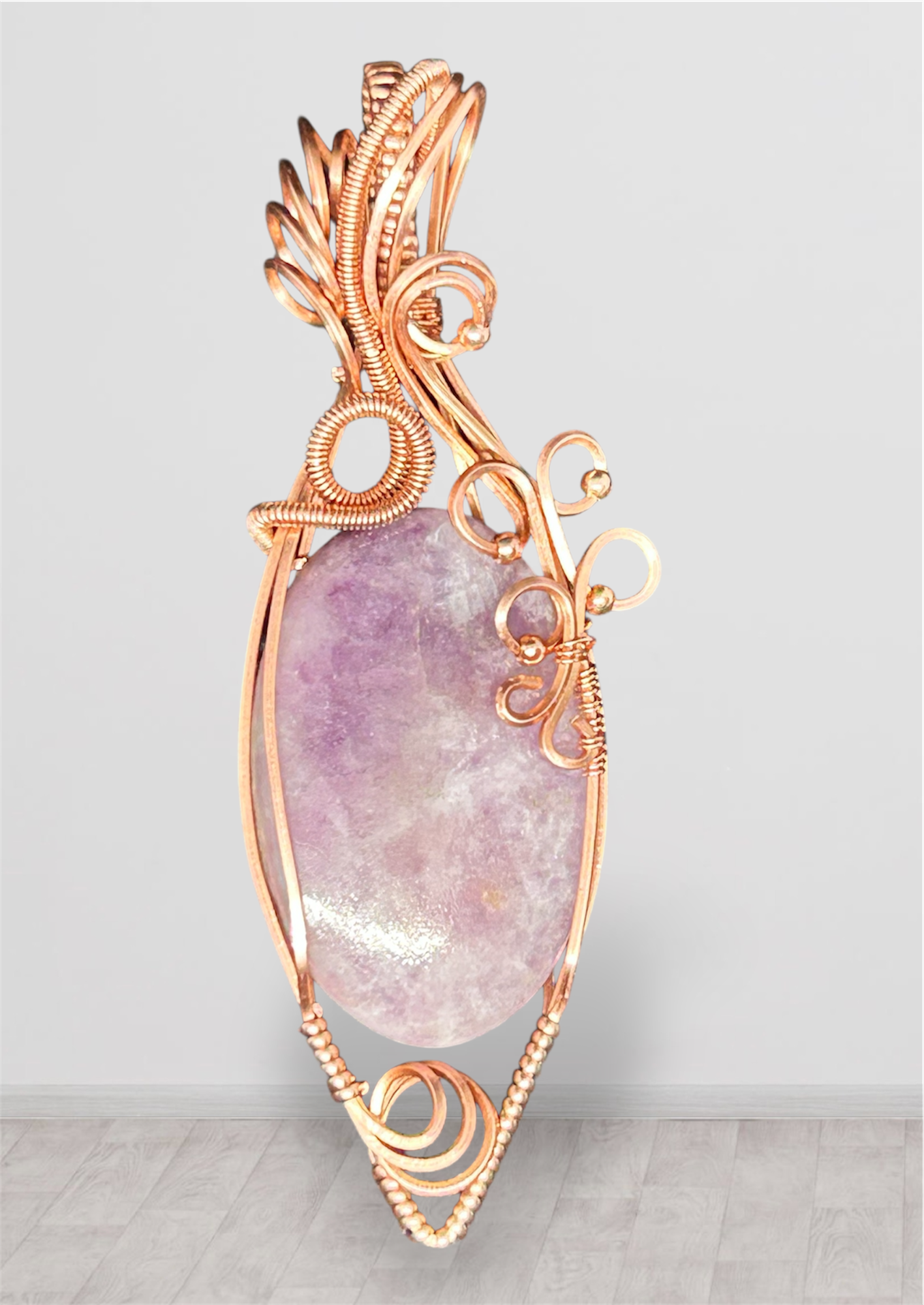 Copper wire wrapped Lepidolite pendant with feather bail and scroll flourishes on white background